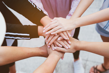 Close up at the hands many teenage girls. Show unity as a collaborative work together. To succeed,...