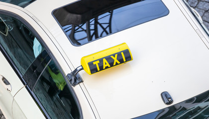 Top view from a white taxi and yellow taxi sign. View from above, part of the car, space.