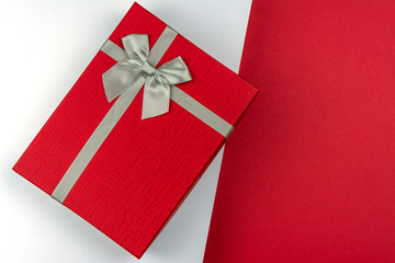 Red gift box with bow on red and white background