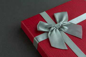 Red gift box with bow grey background. Close up