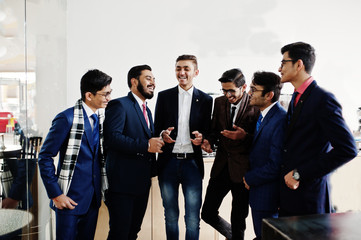Group of six indian business man in suits standing on cafe and disscuss something.