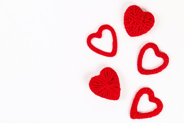 Valentine day layout. Red homemade diy hearts made of cardboard and yarn on a white background. Idea St. Valentines Day, day love, February 14 concept. Copy space, top view, flat lay composition.