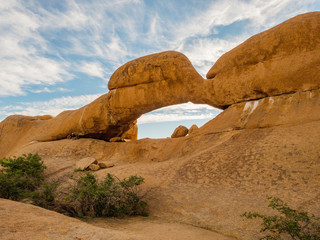 The Bridge, a natural arch at Spitzkoppe, Namibia with the Pondok mountains peeping through
