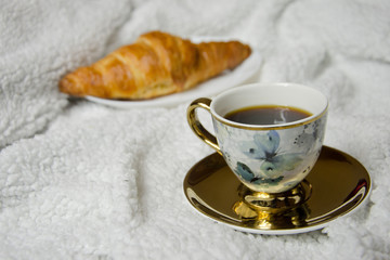 cup of coffee and croissant on white background