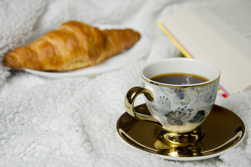 cup of coffee and croissant on white background
