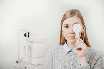 Young woman reception doctor ophthalmologist to check quality of eye vision. - obrazy, fototapety, plakaty