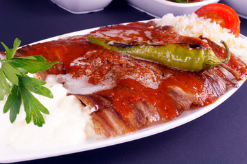 Turkish iskender kebab on dark background. Traditional flavors. Doner kebab made from beef and lamb. close up