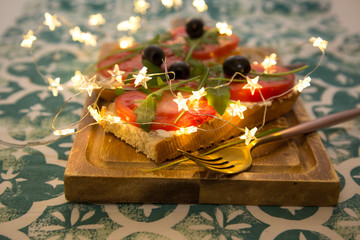 Healthy snack or Tomato, arugula, olives and creamy cheese on toast bread. French or italian Organic breakfast 