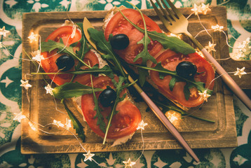Healthy snack or Tomato, arugula, olives and creamy cheese on toast bread. French or italian Organic breakfast 