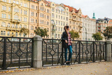 Obraz na płótnie Canvas Young beautiful girl on the street in Prague in the Czech Republic. In the background is urban architecture.