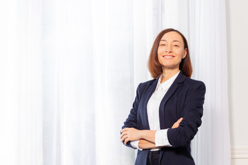 Confident businesswoman standing with arms crossed portrait