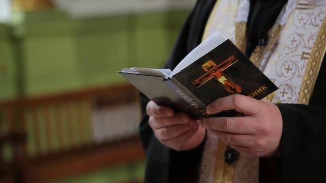missal book in hands of orthodox priest in the chuch, Ukraine