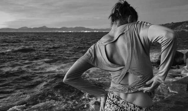 Woman taking off sweater near sea
