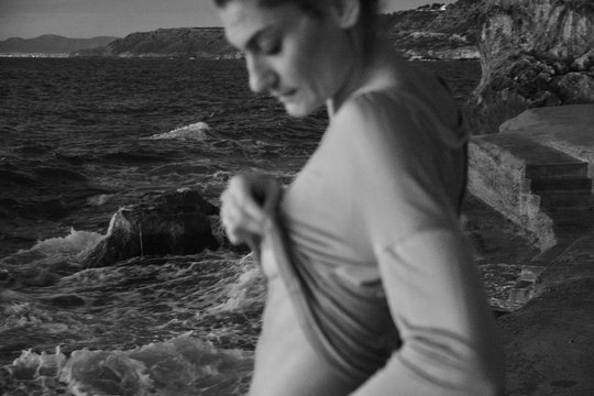 Woman taking off sweater near sea