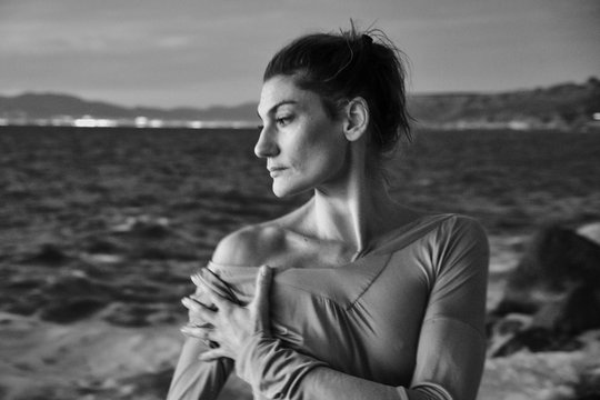 Woman taking off sweater near sea