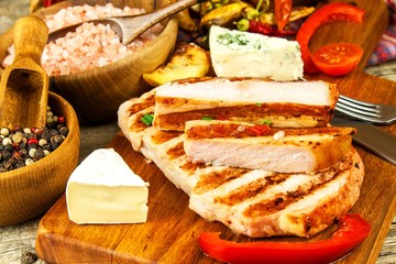 Grilled pork chop on a wooden board. Protein food. Grilled meat. Food preparation. Protein diet.
