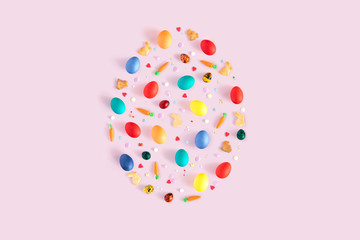 Top view and flat lay of arrangement decoration Happy Easter, holiday background concept. Colorful bunny cookies, eggs and topping ornament design as big egg on pink pastel desk.