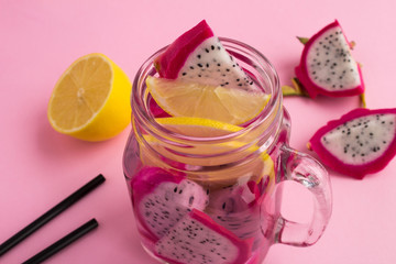 Detox water with dragon fruit and lemon on the pink  background.Closeup.