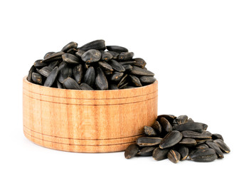 Sunflower seeds in a wooden plate close-up on a white background.