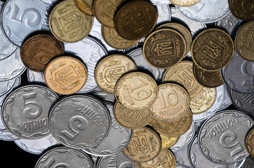 Ukrainian coins isolated on black background. Close-up view. Coins are located at the right side of frame. A conceptual image.