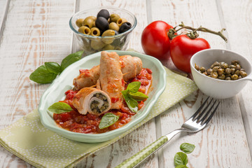 stuffed roll of turkey with capers olives and tomatoes sauce