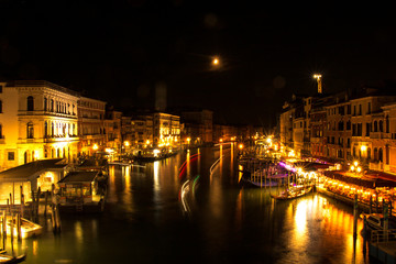 Venice bridge with grand canal views in night.
