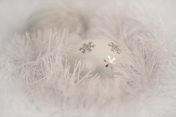 Белы шар со снежинками ледит в мишуре