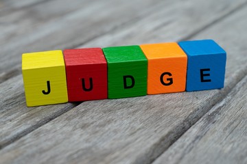 colored wooden cubes with letters. the word judge is displayed, abstract illustration