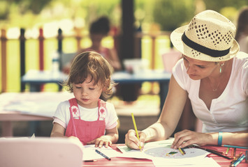 mom and little daughter drawing a colorful pictures