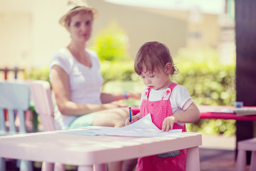 mom and little daughter drawing a colorful pictures