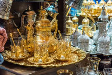 Fototapeta na wymiar Traditional tea sets at Grand Bazaar in Istanbul, Turkey. Golden color teapot and Turkish tea cups..