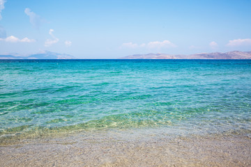 Sea coast and blue turquoise water. Blue sunny sky, summertime.