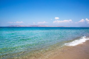 Sea coast and blue turquoise water. Blue sunny sky, summertime.