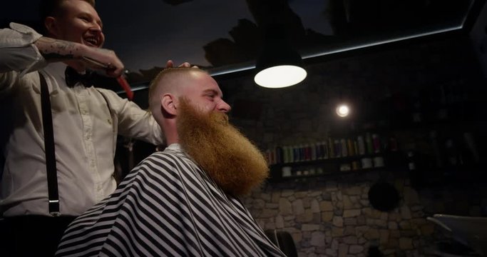 Barber cutting happy client Hair laughing in Barbershop slow motion