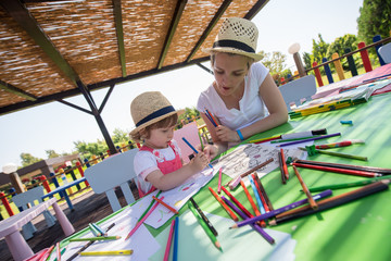 mom and little daughter drawing a colorful pictures