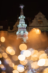 Christmas fair in the market square of Wroclaw with  illumnated christmas tree over the fountain's lights.