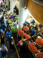 people buying food, fruit and vegetables at a stall in traditional central market in Port Louis, Mauritius