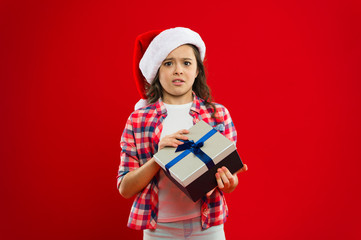 Happy winter holidays. Small upset girl. Present for Xmas. Childhood. Little girl child in santa red hat. Christmas shopping. New year party. Santa claus kid. dont worry.