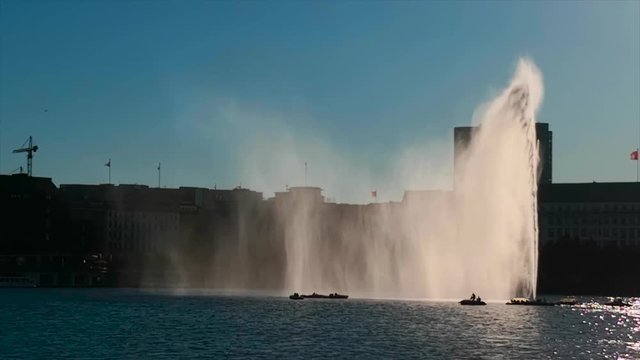 Alster Font&auml;ne Hamburg, Deutschland im Gegenlicht mit Wind und Gischt Wasserschleier