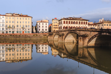 Old buildings reflecting in the Arno River in Florence. Houses with reflection in water