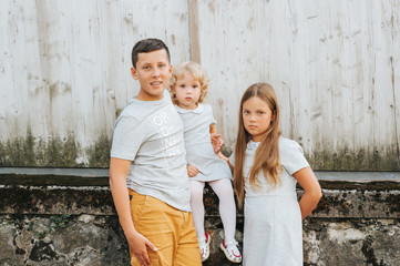 Obraz na płótnie Canvas Group of 3 happy kids, family with teenage boy, little girl and toddler, hugs and love