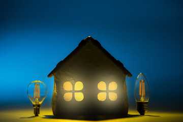 Silhouette led lamps against layout of the house on a blue background