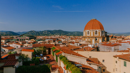Fototapeta na wymiar Dome of San Lorenzo Basilica under blue sky, over houses of the historical center of Florence, Italy