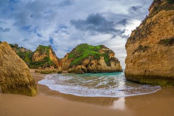 Famous rock formation in a bay on the beach of Tres Irmaos in Alvor, Portimão, Algarve, Portugal, Europe. Praia dos Tres Irmaos.