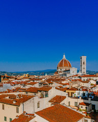 Fototapeta na wymiar Florence Cathedral and Giotto's Bell Tower under blue sky, over houses of the historical center of Florence, Italy