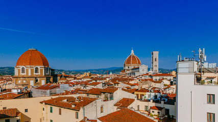 Fototapeta premium Florence Cathedral, Giotto's Bell Tower, and San Lorenzo Basilica under blue sky, over houses of the historical center of Florence, Italy