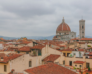 Florence Cathedral and Giotto's Bell Tower, under overcast sky, over houses of the historical center of Florence, Italy