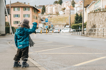 Little child raising hand on the bus station, image taken in Lausanne, Switzerland