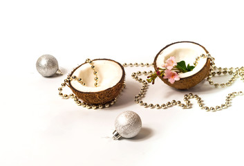 Creative layout of coconuts, concept of New Years holiday.Decorative Garland and silver balls on pink background, Christmas decor
