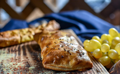 Traditional Georgian khachapuri on the table with grapes. Homemade baking recipe.